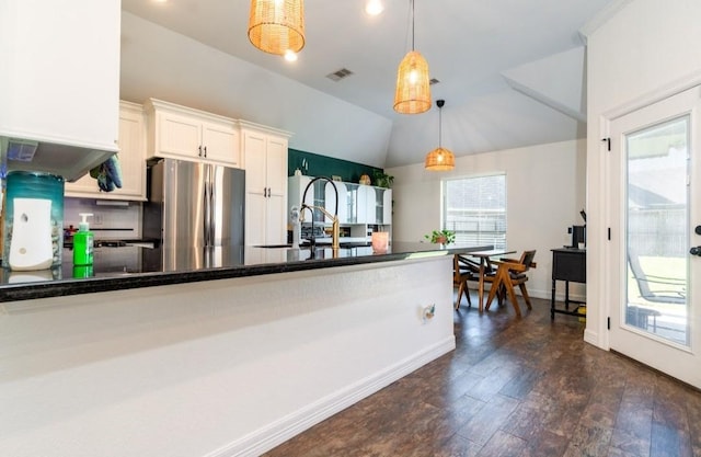 kitchen featuring dark wood-style flooring, visible vents, hanging light fixtures, freestanding refrigerator, and vaulted ceiling