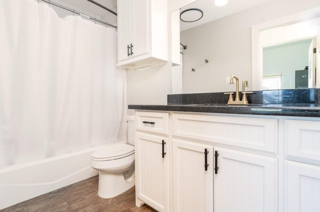 full bathroom featuring toilet, shower / tub combo, wood finished floors, and vanity