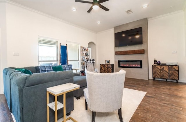 living area featuring ornamental molding, arched walkways, dark wood-style flooring, and visible vents