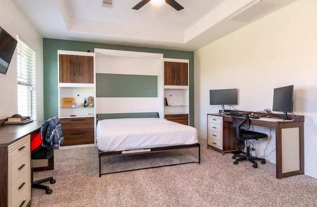 bedroom featuring light colored carpet, a raised ceiling, and visible vents