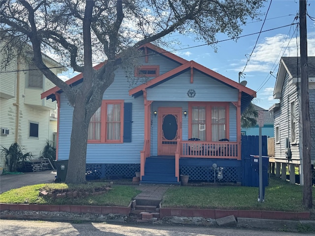 bungalow-style house with a front yard and covered porch