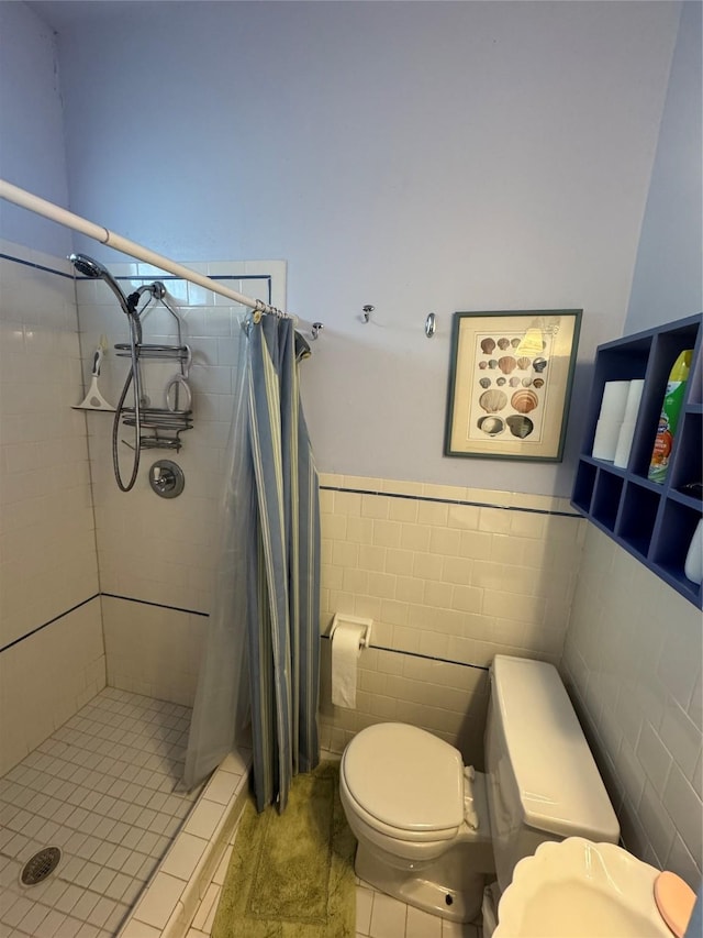 bathroom with toilet, a wainscoted wall, a shower stall, and tile walls