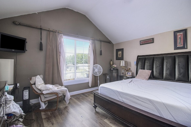 bedroom featuring lofted ceiling, baseboards, and wood finished floors