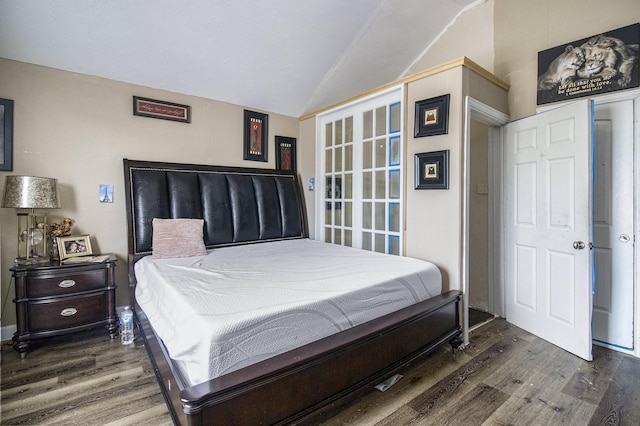 bedroom with lofted ceiling and wood finished floors