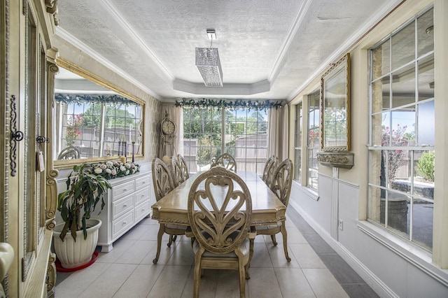 dining area featuring a healthy amount of sunlight, a textured ceiling, a tray ceiling, and crown molding