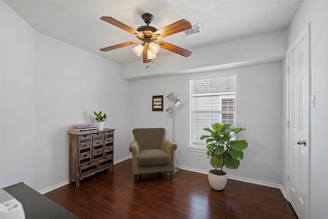 living area featuring visible vents, ceiling fan, baseboards, and wood finished floors