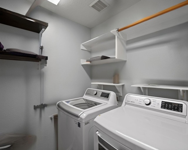 clothes washing area featuring laundry area, separate washer and dryer, and visible vents