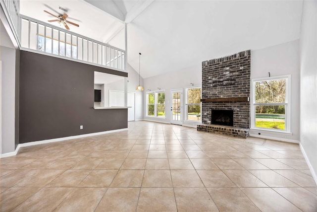 unfurnished living room featuring ceiling fan, high vaulted ceiling, a fireplace, baseboards, and tile patterned floors