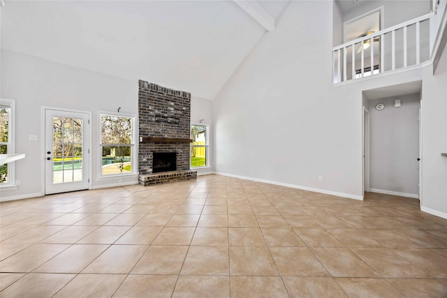 unfurnished living room with light tile patterned floors, a brick fireplace, baseboards, and beam ceiling