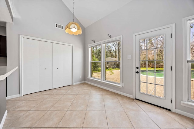 entryway with light tile patterned floors, high vaulted ceiling, visible vents, and baseboards