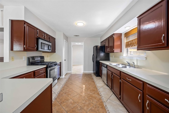 kitchen featuring baseboards, visible vents, stainless steel appliances, light countertops, and a sink