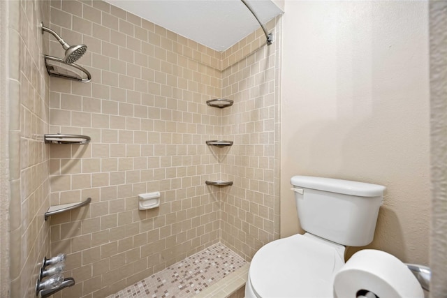 full bath featuring tiled shower and toilet