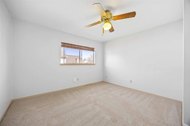 empty room featuring carpet floors, a ceiling fan, and baseboards