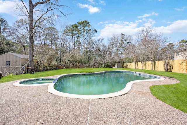 view of swimming pool featuring a yard, a fenced backyard, and a pool with connected hot tub