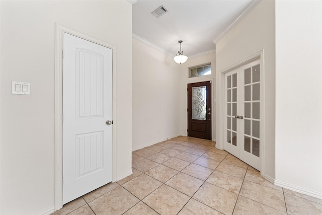 foyer with ornamental molding, visible vents, baseboards, and light tile patterned flooring