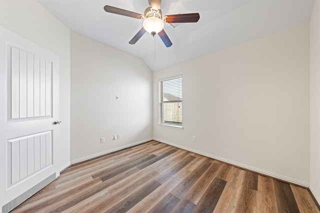 spare room with lofted ceiling, ceiling fan, baseboards, and wood finished floors