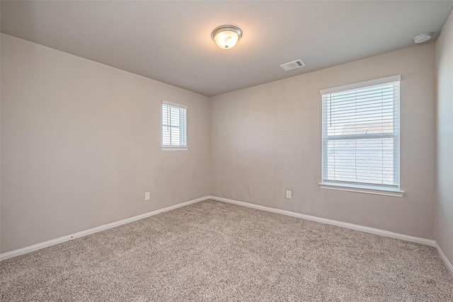 spare room featuring visible vents, carpet flooring, and baseboards