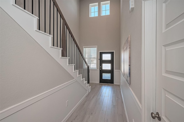 entrance foyer with a wealth of natural light, stairway, and light wood-type flooring