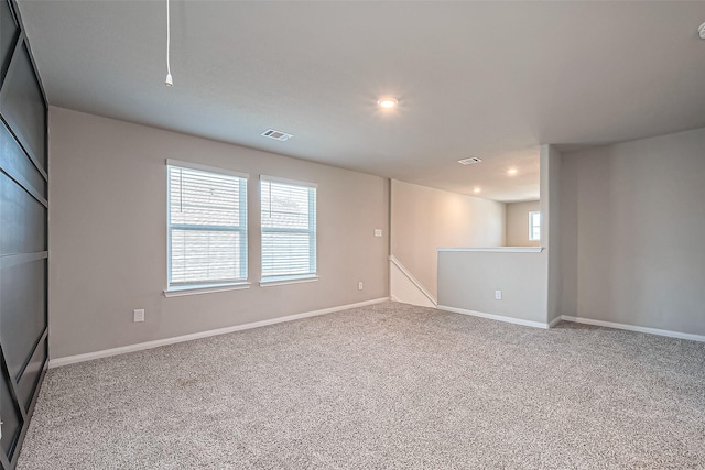 unfurnished room featuring baseboards, visible vents, attic access, recessed lighting, and carpet flooring