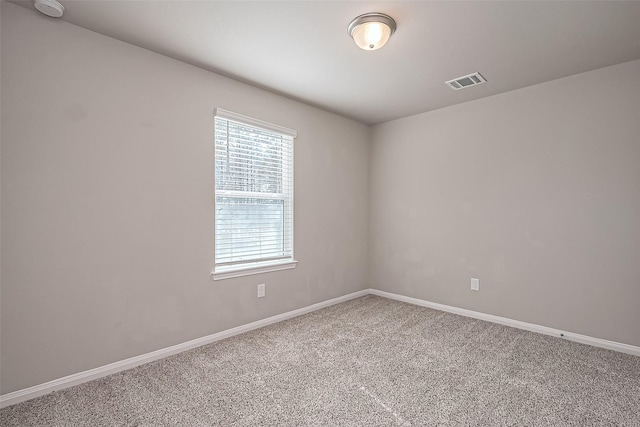 carpeted empty room featuring visible vents and baseboards