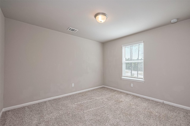 carpeted empty room featuring visible vents and baseboards