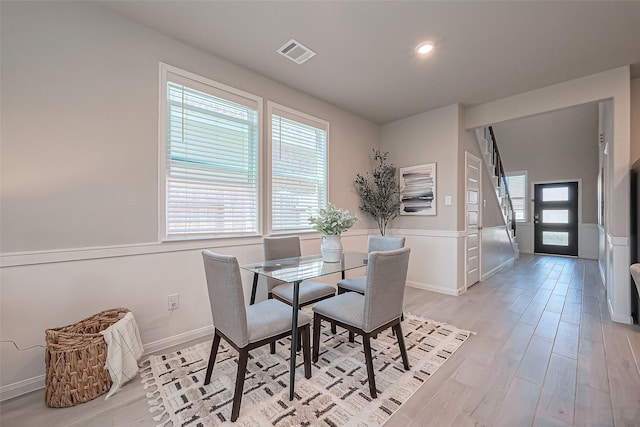 dining room with light wood-style flooring, baseboards, and visible vents