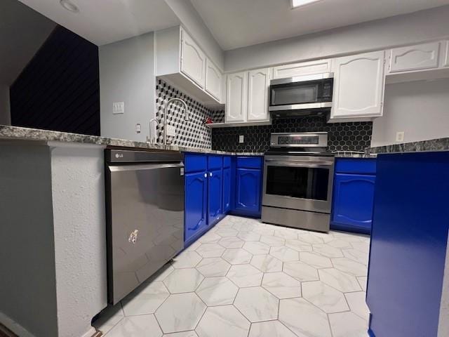 kitchen featuring blue cabinetry, appliances with stainless steel finishes, and white cabinets