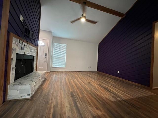 unfurnished living room featuring dark wood finished floors, ceiling fan, a fireplace, high vaulted ceiling, and beam ceiling