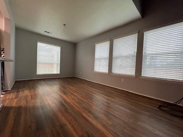 unfurnished living room featuring dark wood finished floors and visible vents