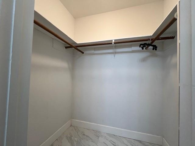 spacious closet with marble finish floor