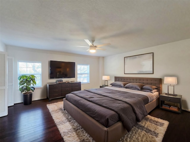 bedroom featuring dark wood-style floors, a textured ceiling, and a ceiling fan