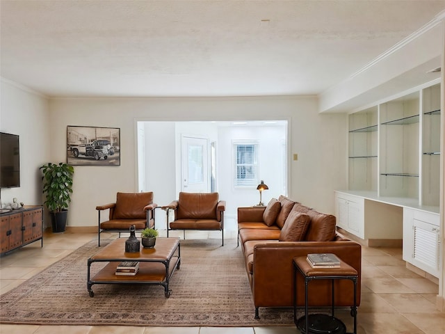 living area featuring crown molding, light tile patterned floors, baseboards, and built in study area