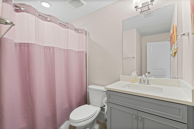 bathroom featuring toilet, vanity, and visible vents