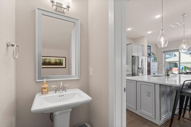 bathroom with visible vents, wood finished floors, a sink, and recessed lighting