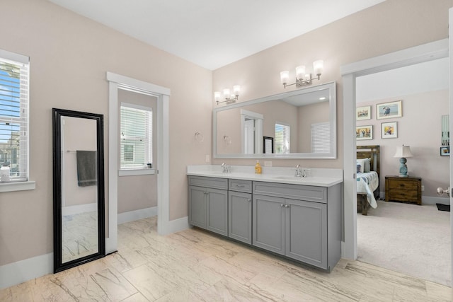 bathroom with double vanity, marble finish floor, connected bathroom, and a sink