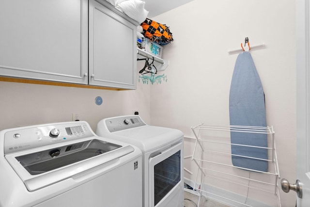 washroom with cabinet space and washer and dryer