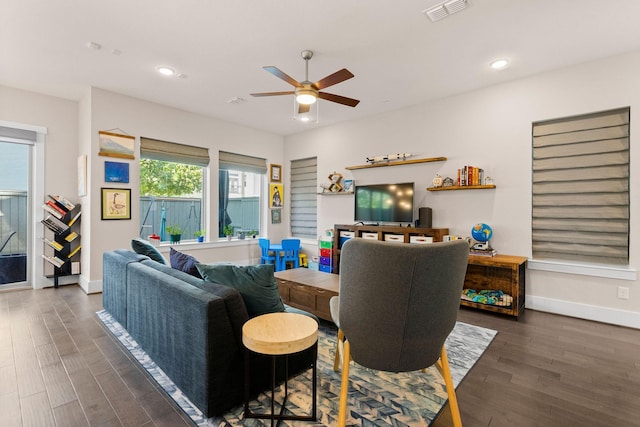 living room featuring recessed lighting, dark wood-style flooring, visible vents, and baseboards