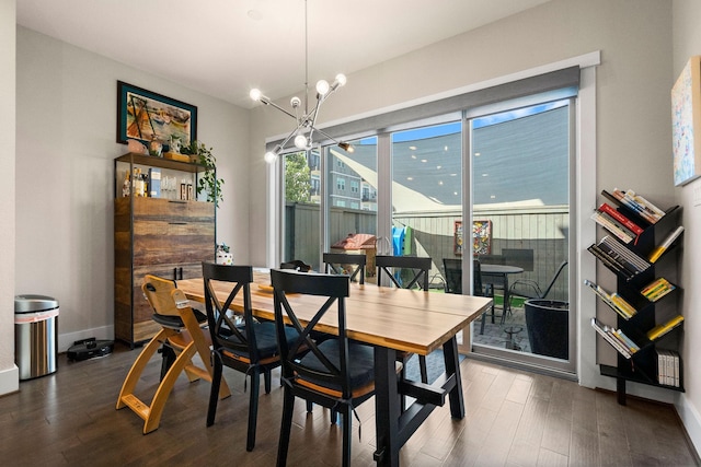 dining area featuring a chandelier, dark wood-style flooring, and baseboards