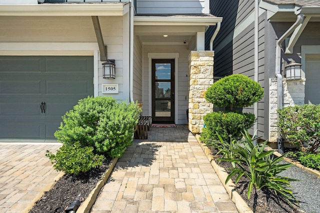 view of exterior entry featuring a garage and stone siding