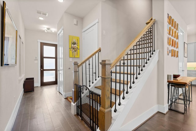 stairs with visible vents, baseboards, and wood finished floors