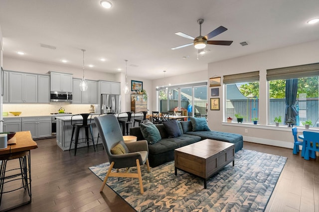 living room featuring dark wood-style floors, a ceiling fan, visible vents, and recessed lighting