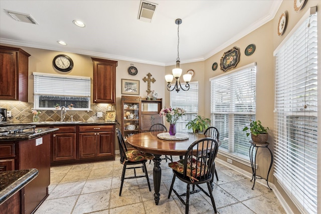 dining space with stone tile flooring, visible vents, and crown molding