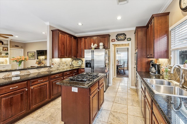 kitchen with stone tile floors, black gas cooktop, backsplash, ornamental molding, and a sink