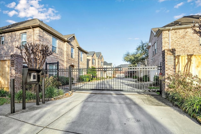 view of street featuring a residential view, a gate, and a gated entry