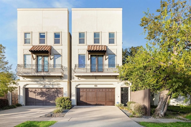 view of property featuring concrete driveway, an attached garage, a tiled roof, and stucco siding