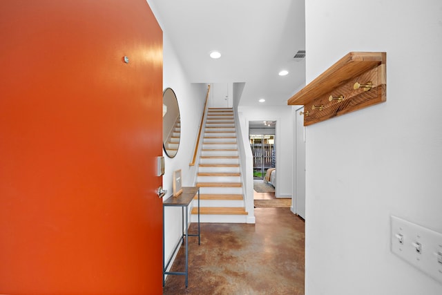 entryway with recessed lighting, visible vents, baseboards, finished concrete flooring, and stairway