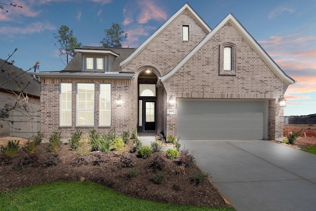 view of front of house featuring driveway and brick siding