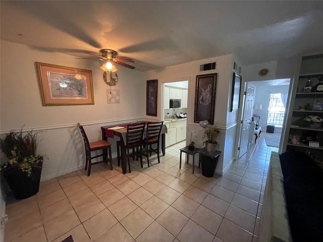 dining room featuring visible vents, ceiling fan, baseboards, and light tile patterned floors