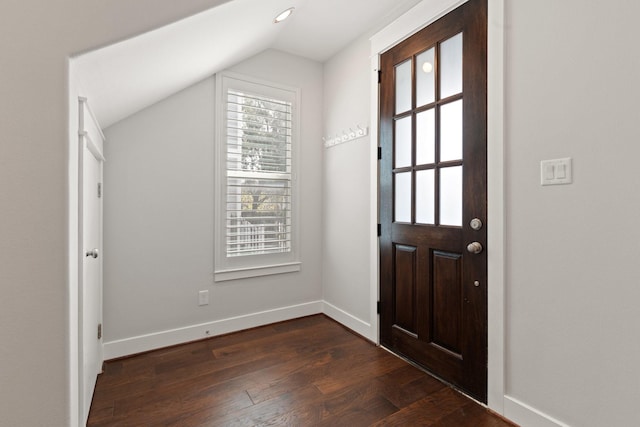 entrance foyer with dark wood-style floors, vaulted ceiling, and baseboards