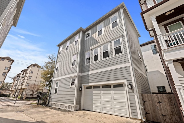 view of front of home featuring concrete driveway, fence, and an attached garage